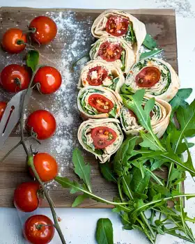 Vegetarische Wrap-Röllchen mit Rucola und Tomaten